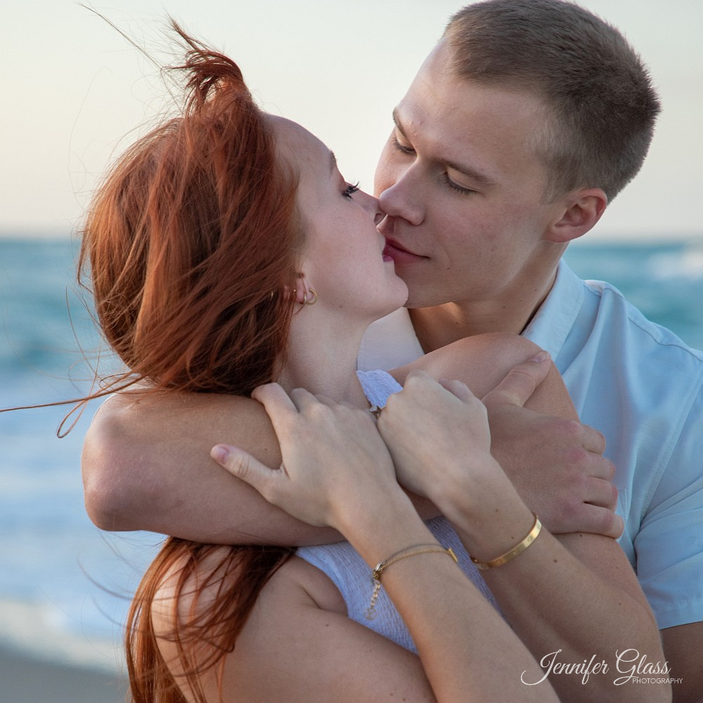 Attractive couple kiss beach photo
